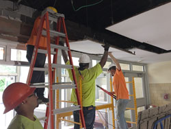 Workers install drop ceiling