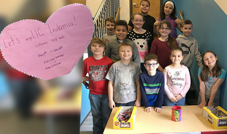 group of elementary students standing on stairs of school with lollipop sale table and heart sign reading let's lic leukemia