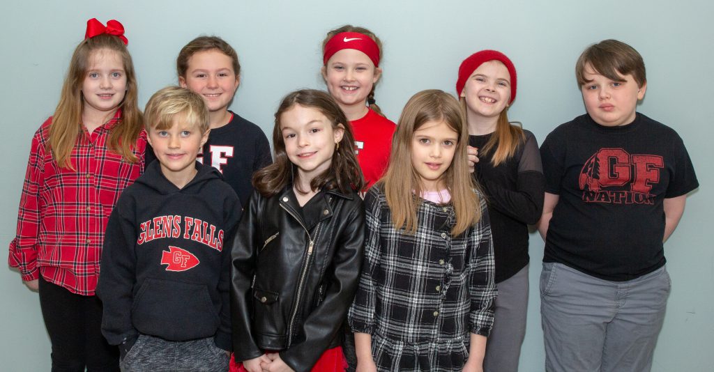 group of elementary students smiling in red and black clothing