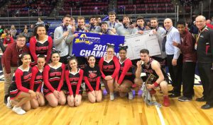 basketball team and cheerleaders with medals and banner on gym court