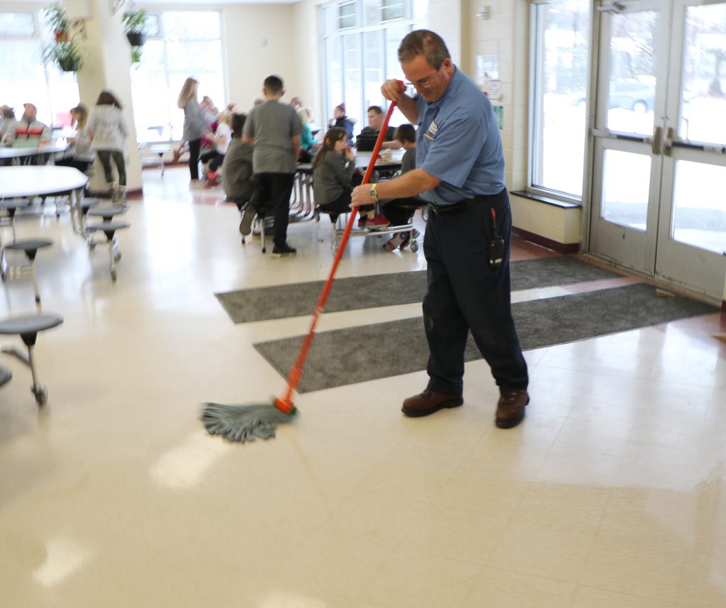custodian mopping school cafeteria floor