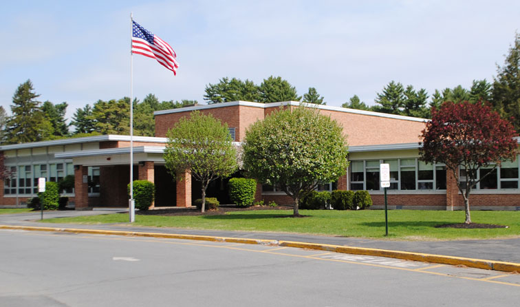 exterior front of Kensington Road elementary school during summer with American flag waving