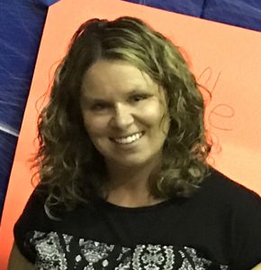 woman smiling wearing black and shite shirt