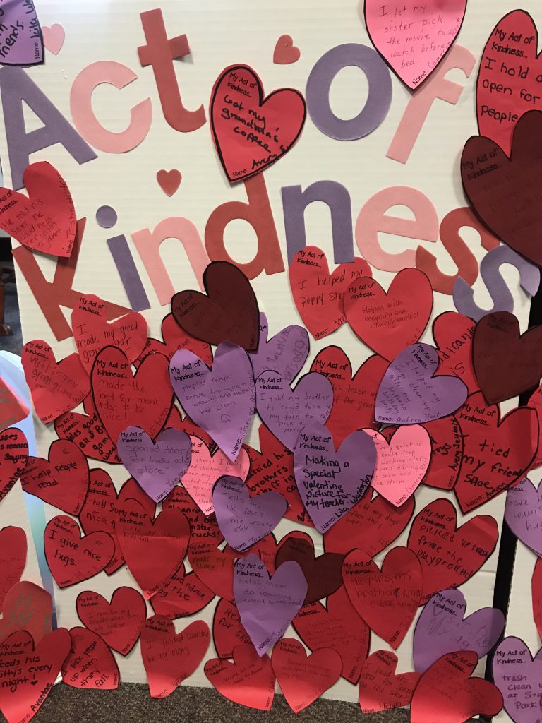 red and purple paper heart cut-outs with acts of kindness written on them