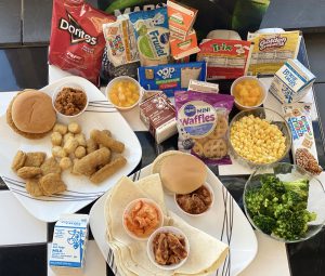 holiday meal bag items displayed including waffles, broccoli, breakfast cereals, chicken nuggets, milk cartons
