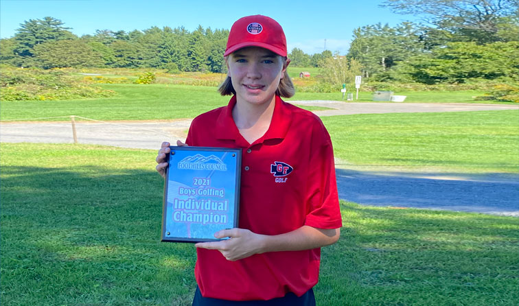student golfer holding championship plaque outside on golf course