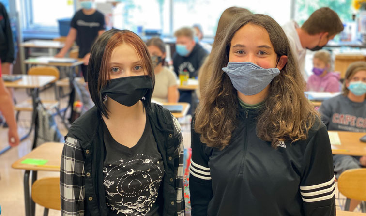 two students in classroom wearing masks