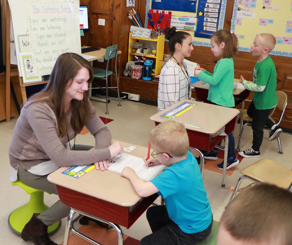 two teachers working with students in classroom