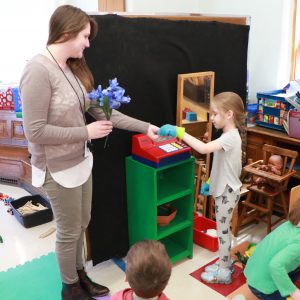teacher and student playing flower shop in the kindergarten classroom