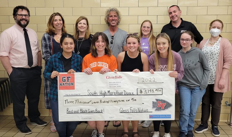 group of teachers and students holding a giant check for the south high marathon dance