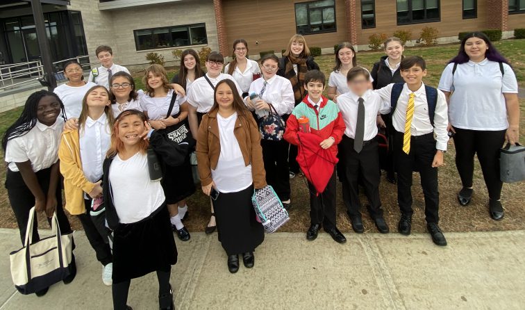 group of students in concert attire outside a school building during the all-county choral festival