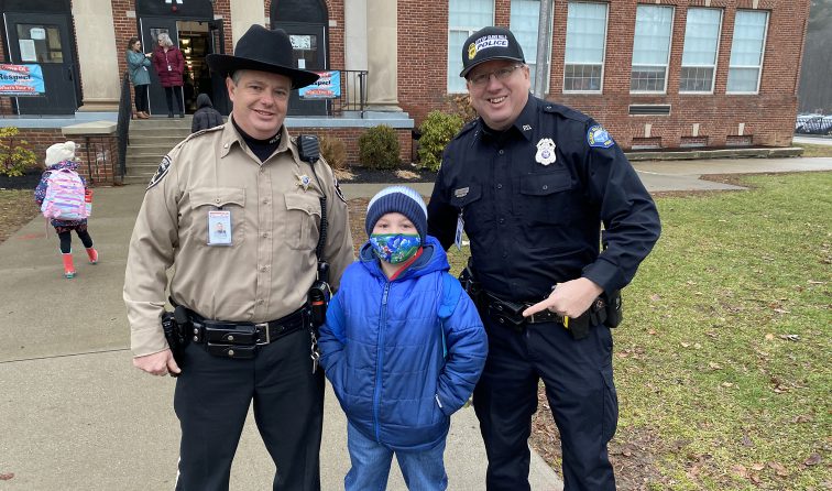School Resource Officers greet an elementary student outside school