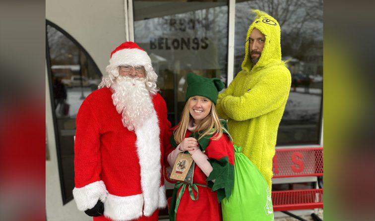 staff members dressed up in holiday costumes greeting students