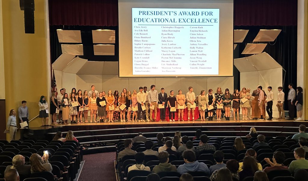 large group of students on a stage accepting awards