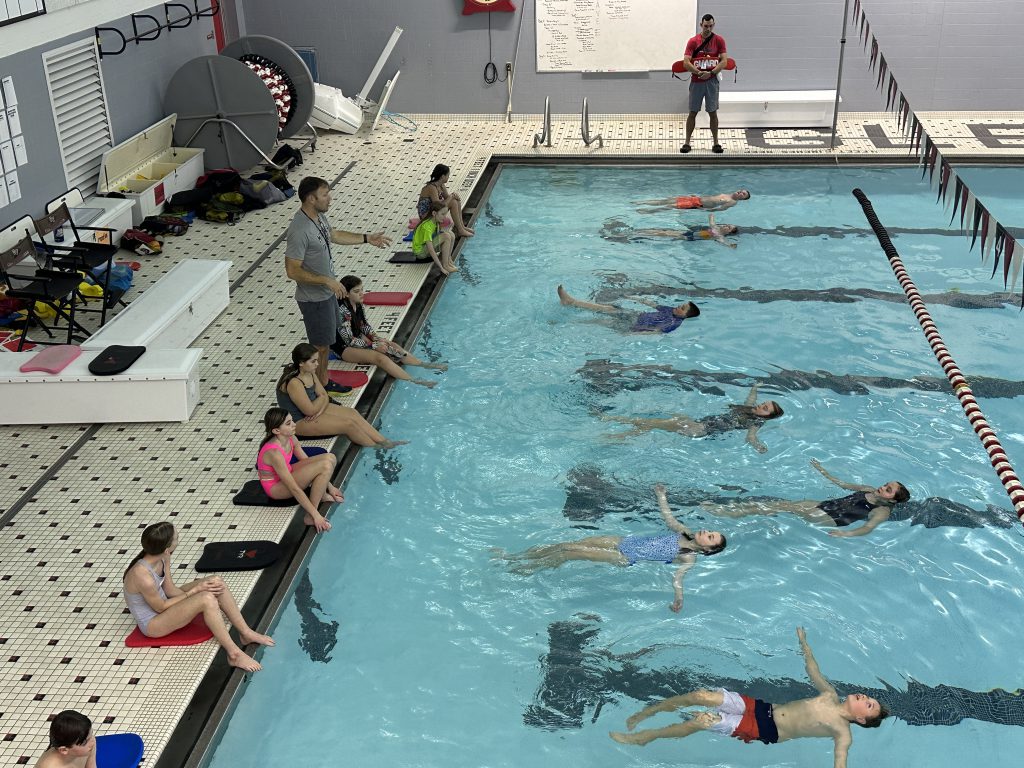 Several students practice back floats in the GFHS pool