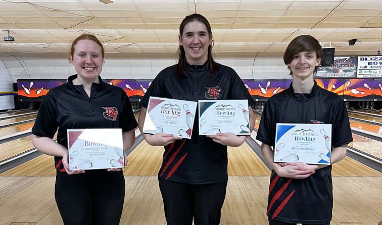 three bowlers stand in front of the lanes holding certificates and smiling