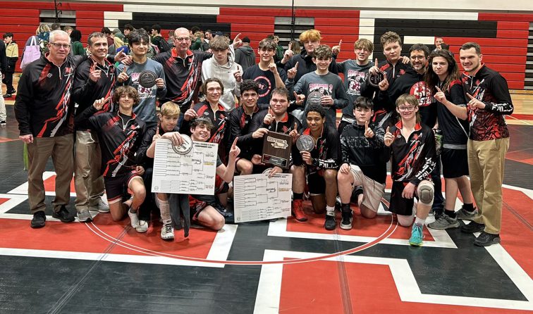 group of wrestling team members celebrating their Class CC Sectional win with patches and the plaque