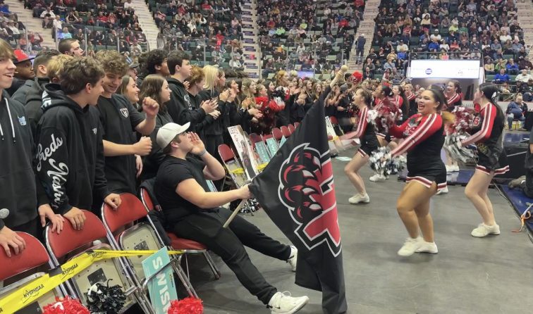 cheerleaders hyping up the student section crowd during the state championship basketball game