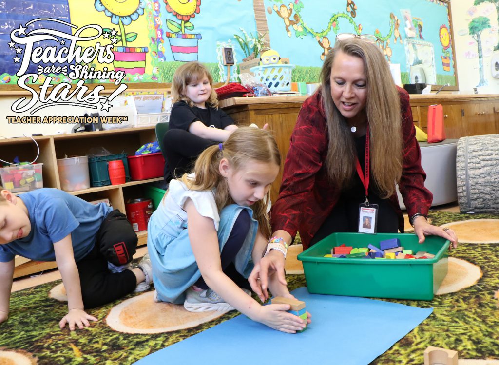 Kindergarten teacher with students on the classroom rug using blocks to build a ramp as part of a science lesson on force